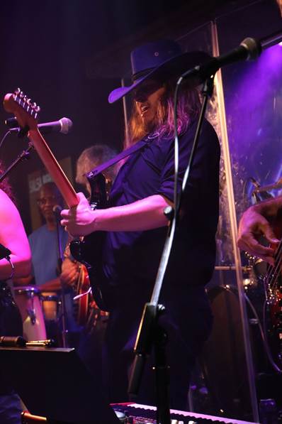 A person playing guitar on stage

Description automatically generated